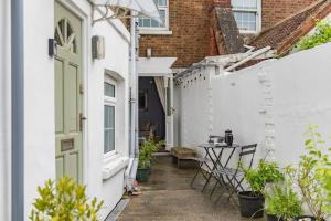 a small alley with a green door and a table at Curious Cottage in Deal