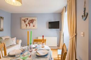 a dining room with a table with wine glasses at Curious Cottage in Deal