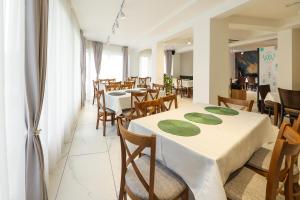 Un restaurante con mesas y sillas blancas y ventanas. en GRAFFIT Luxury houses, en Ognyanovo