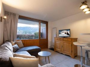 salon z kanapą i dużym oknem w obiekcie Charmant 2 pièces, 4 pers, proche pistes et commerces avec garage à La Clusaz - FR-1-304-281 w mieście Clusaz