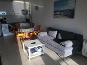 a living room with a couch and a table at Swimming Apartment in Rijeka