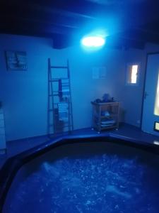 einen Pool in einem Zimmer mit blauem Licht in der Unterkunft Les Amandiers de Jade in Saint-Agnet