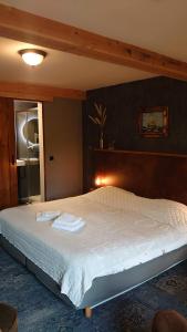 a bedroom with a large bed with white sheets at De Cyprian Bed & Breakfast in Baaiduinen