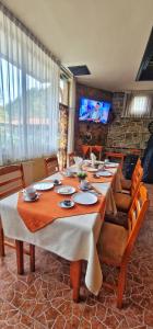 a large dining room with a long table and chairs at Семеен Хотел Бачково in Bachkovo