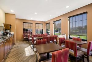 un restaurante con mesas, sillas y ventanas en Comfort Inn Virginia Horse Center, en Lexington