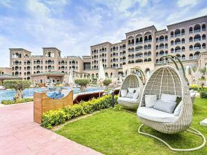 Royal Saray Resort في المنامة: منتجع فيه كرسيين الخوص في الساحه