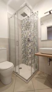 een badkamer met een douche, een toilet en een wastafel bij Villa Feluchia Tra Il Mare E Il Vulcano in Acireale
