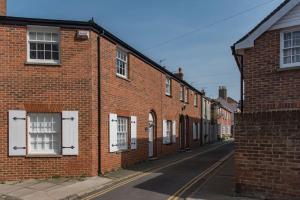 a brick building with white doors on a street at Corner House in Deal