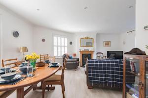 a living room with a dining room table and a fireplace at Corner House in Deal