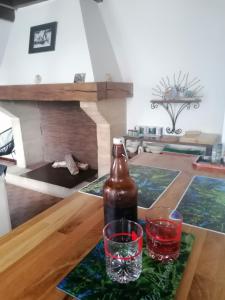 1 Flasche und 2 Gläser auf einem Tisch im Wohnzimmer in der Unterkunft Les Amandiers de Jade in Saint-Agnet