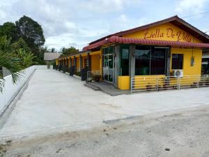 um edifício amarelo com uma rua em frente em Ziella De Villa em Pantai Cenang