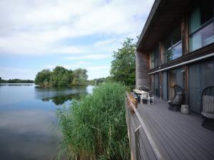 een huis met een terras met uitzicht op een rivier bij The Lakes By YOO in Lechlade