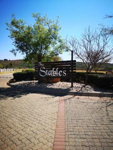 a sign for the one stables sign in a park at Mooikloof Mews with Solar Backup in Pretoria