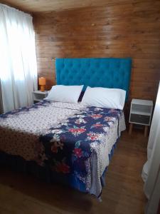 a bedroom with a bed with a blue head board at Camping las islas in Panimávida