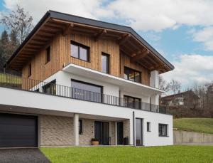 a house with a wooden roof at Bergzeit Appartement in Hopfgarten im Brixental