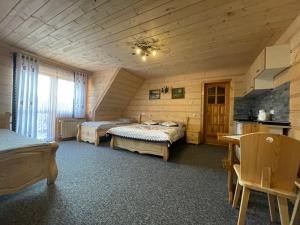 een slaapkamer met 2 bedden in een houten kamer bij U Maćka in Poronin