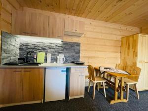 a kitchen with a counter and a table with chairs at U Maćka in Poronin