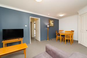 een woonkamer met een bank en een tafel bij Hornsby Furnished Apartments in Hornsby