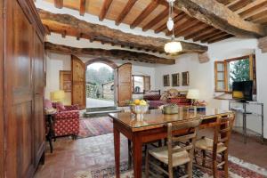 una sala de estar de planta abierta con mesa de madera y sillas. en Castello di Bibbione en San Casciano in Val di Pesa