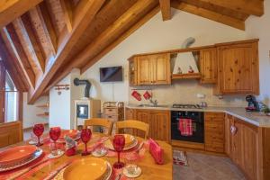 a kitchen with a wooden table with wine glasses on it at Happy Guest Apartments - Alpin Chalet Borno in Borno