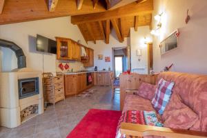a living room with a couch and a kitchen at Happy Guest Apartments - Alpin Chalet Borno in Borno +8 photos