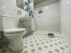 um banheiro branco com vaso sanitário e chuveiro em 郵系空間民宿 em Zhuqi