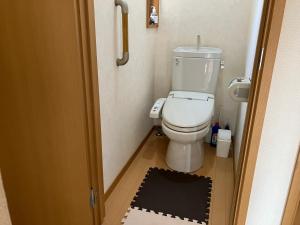 a small bathroom with a toilet and a black rug at 3 Bedrooms, 2 Toilets, 3 Car parking in Big Entire house Close to Makuhari Messe, Disneyland, airport and Tokyo for 12 guests in Kuguta
