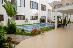einen Innenhof mit einem Pool in einem Gebäude in der Unterkunft Hôtel Millennium Kamissa in Bamako