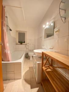 a bathroom with a tub and a toilet and a sink at Schöne Ferienwohnung in Laurenburg in Laurenburg