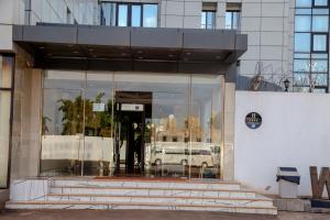 ein Gebäude mit einer Drehtür mit einem Auto im Fenster in der Unterkunft Hôtel Millennium Kamissa in Bamako
