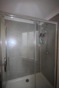 y baño con ducha y puerta de cristal. en Flat 1 Alfred Mews, en Deal