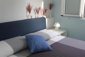 a bedroom with a bed with a blue pillow on it at Casa Azzurra in Cetara