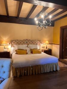 a bedroom with a large white bed with a chandelier at Palacio de Cutre in La Goleta