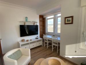 a living room with a television and a table with chairs at Casa Da Ponte By Oktheway in Puentedeume