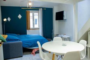 a bedroom with a bed and a table and chairs at Cosy à Guist'hau in Nantes