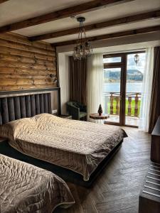 a bedroom with two beds and a large window at OASIS RESORT RHODOPES in Dospat