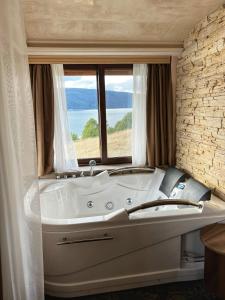 a large white tub in a room with a window at OASIS RESORT RHODOPES in Dospat +39 photos