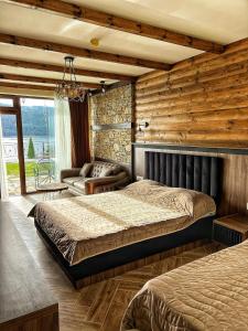 um quarto com 2 camas num quarto com paredes de madeira em OASIS RESORT RHODOPES em Dospat