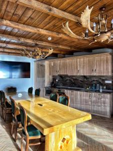 una sala da pranzo con tavolo e sedie in legno di OASIS RESORT RHODOPES a Dospat