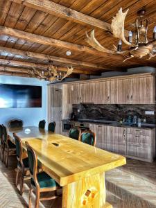 a dining room with a wooden table and chairs at OASIS RESORT RHODOPES in Dospat