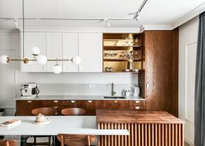 a kitchen with white cabinets and a table with chairs at Mariacka Residence in Gdańsk