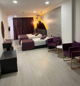 a hotel room with two beds and purple chairs at Karikatür Bi Hotel in Alanya