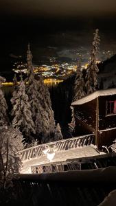 a ski lodge with snow covered trees at night at Kvitfjell Hotel Kvitfjellvegen 492 in Kvitfjell +5 photos