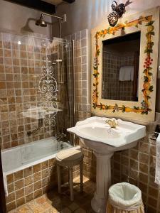 a bathroom with a sink and a tub and a mirror at Palacio de Cutre in La Goleta