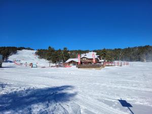 豐羅默奧代洛維亞的住宿－appartement rénové avec une magnifique vue，雪覆盖的滑雪场,后面是滑雪小屋
