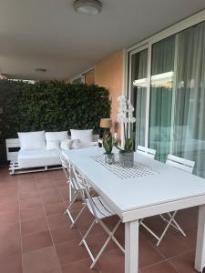 una mesa blanca y sillas en un patio con sofá en Gardazzurro en Padenghe sul Garda