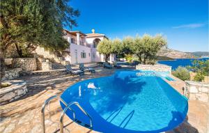 a swimming pool with blue water in front of a house at Villa Sophia in Évyiros