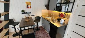 a small kitchen with a counter and chairs in it at Pine Nook in Ogre
