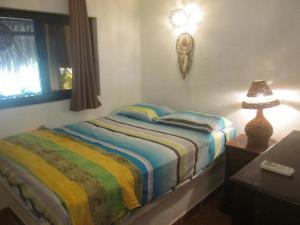 ein Schlafzimmer mit einem Bett und einer Lampe auf einem Tisch in der Unterkunft Marbella Eco Lodge in Monterrico