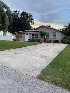a house with a driveway in front of a house at Cozy Home in a Golf kart neighborhood and private pool in Palm Harbor